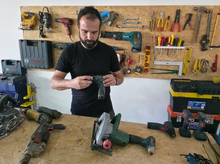Instrutor realizando manutenção em uma parafusadeira na oficina